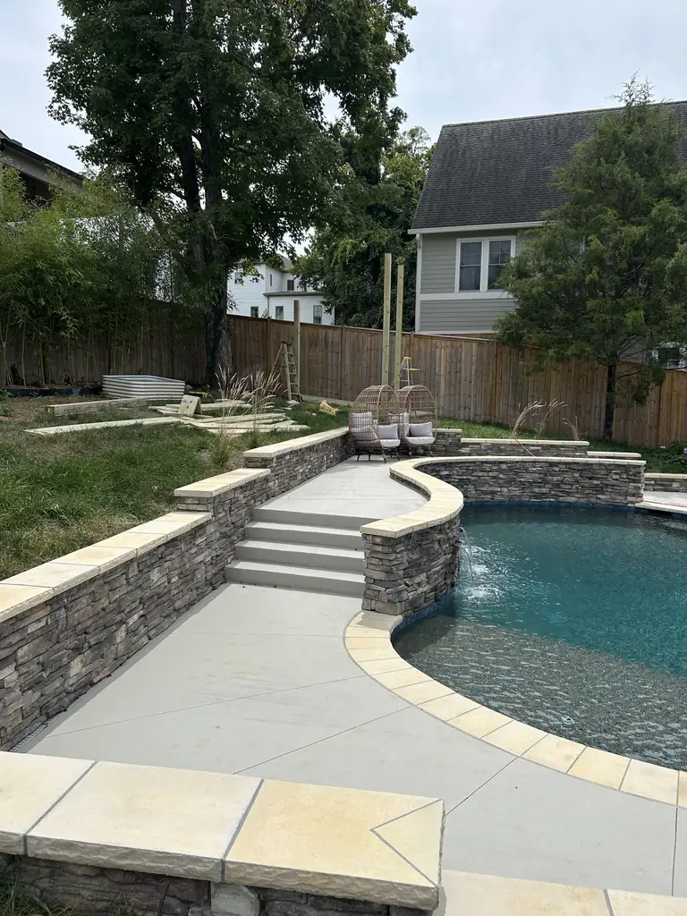 Pool patio with a curved stone retaining wall and steps in Nashville, Tennessee
