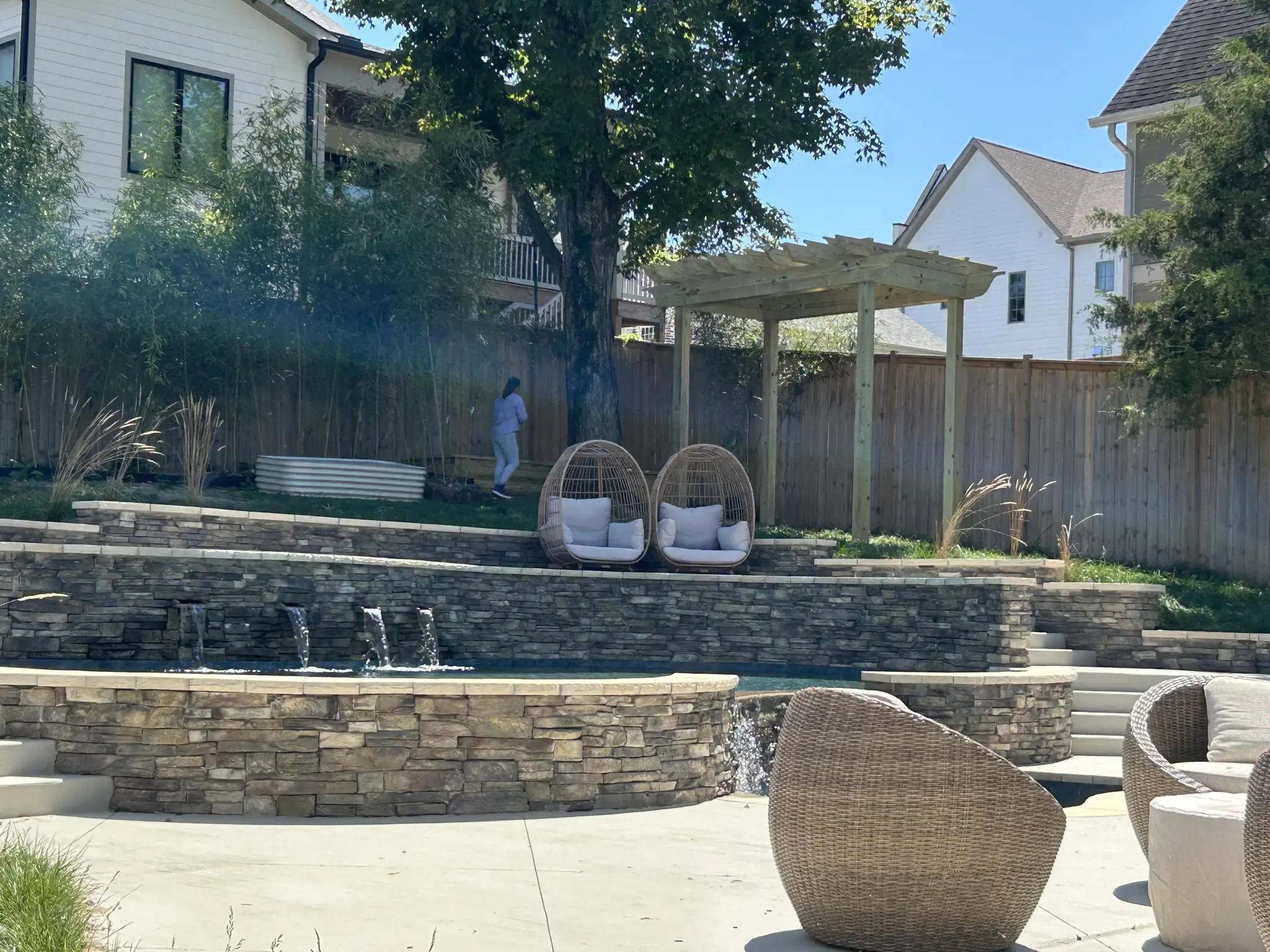 Tiered stone patio with retaining walls and a pergola in Nashville, Tennessee